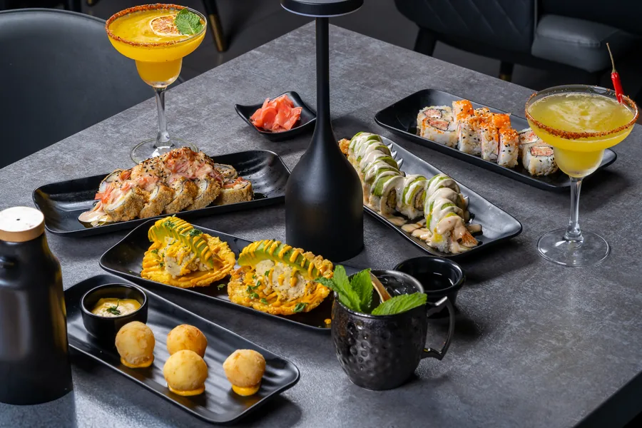 Cocktails and sushi on a set table at KamiKoi
